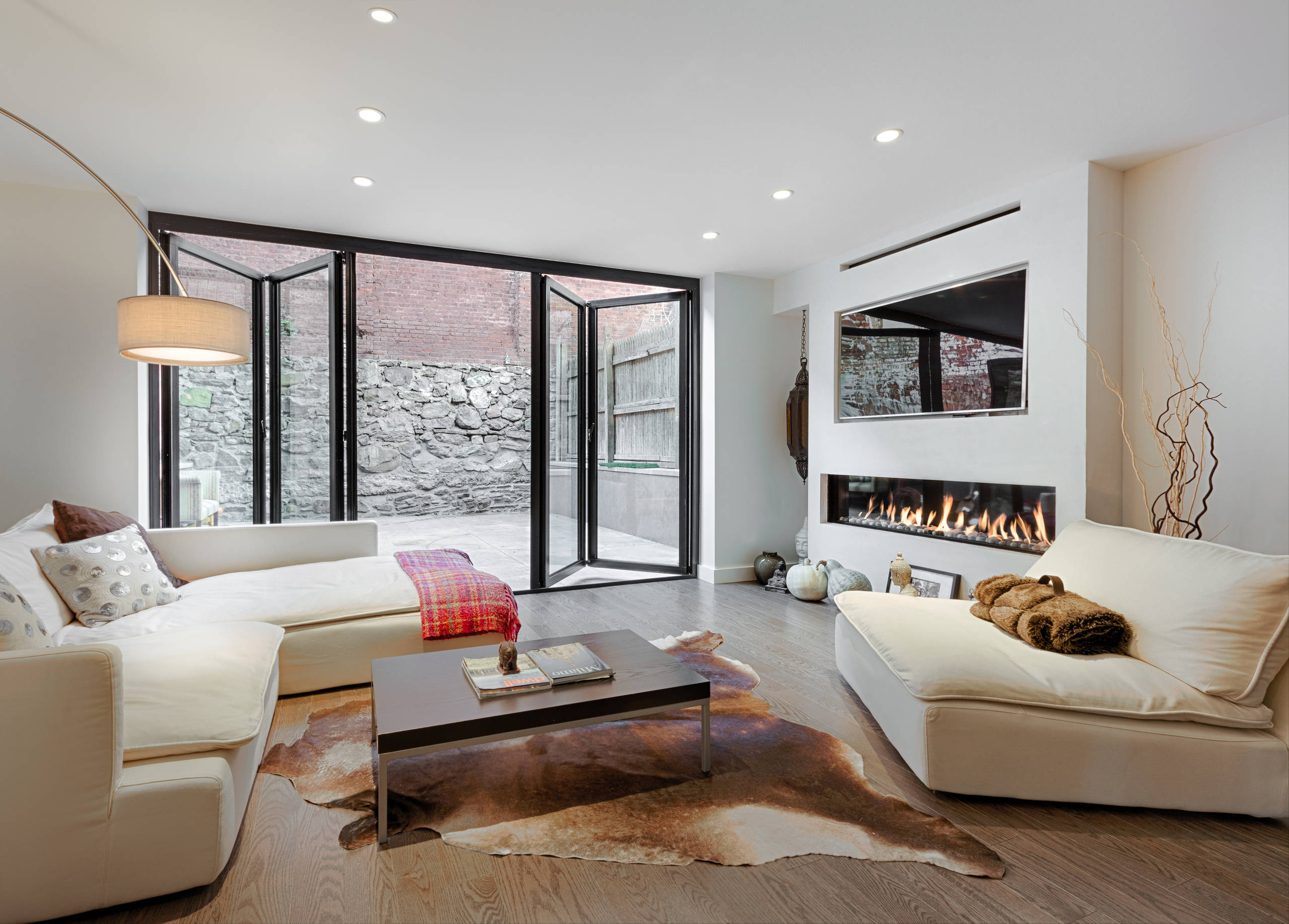 Carroll Gardens Townhouse Renovation — garden-level living room with bifold doors to rear yard